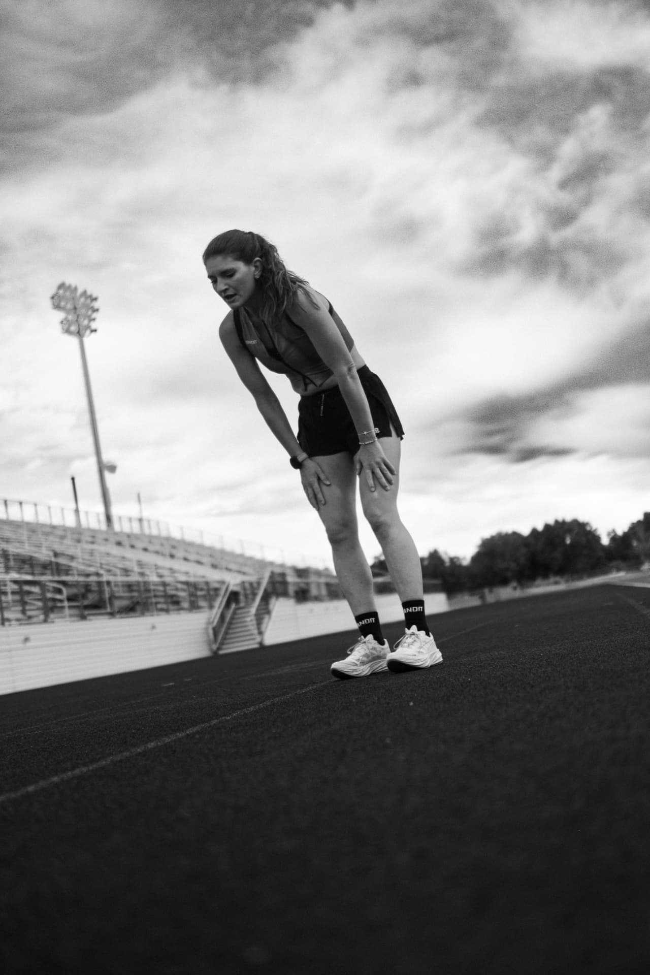 Elite marathoner catching her breath on the track after a hard workout